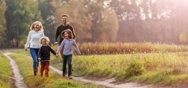 Happy family running down pathway together